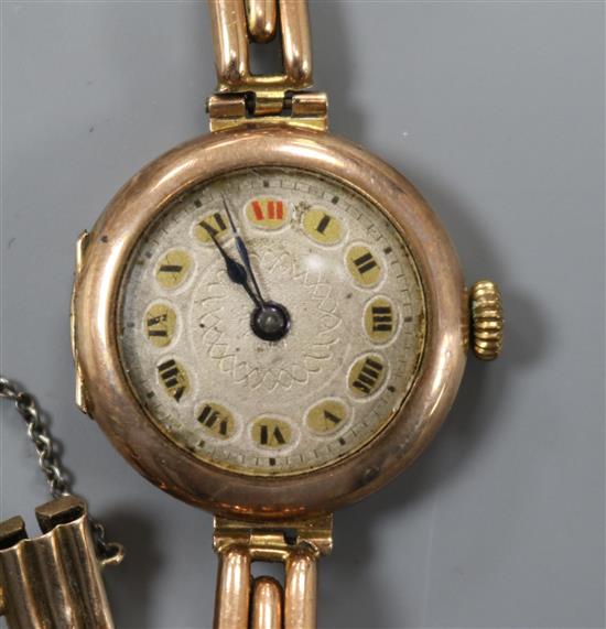 A ladys early 20th century 9ct. gold manual wind wrist watch on a 9ct gold bracelet.